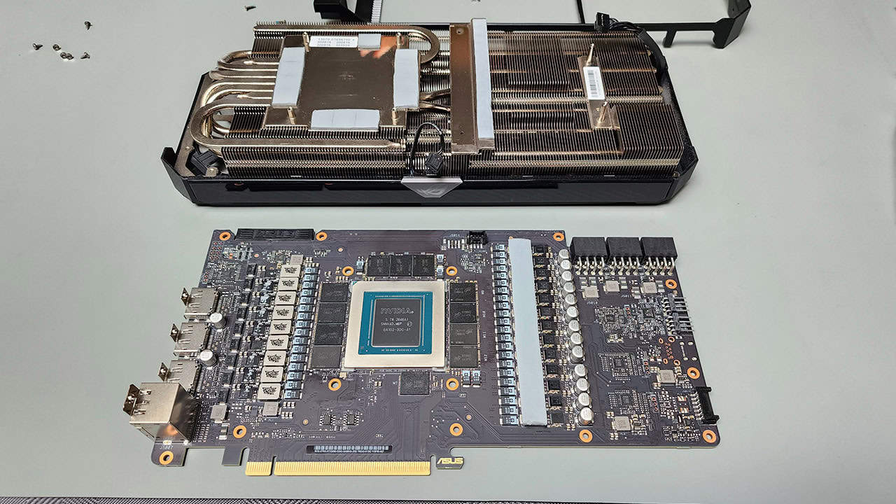 Graphics card heatsink separated from the circuit board, exposing the bare NVIDIA GPU die in the center of the board.
