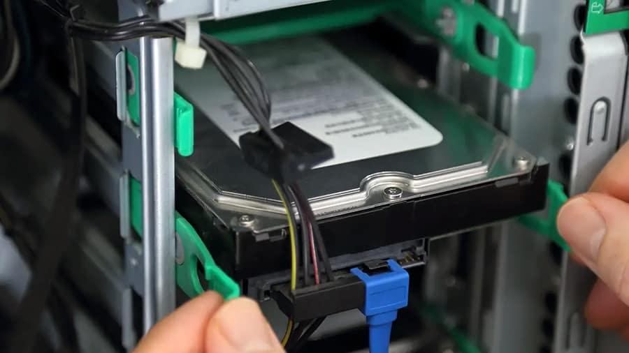 A hard drive is being mounted inside a computer.