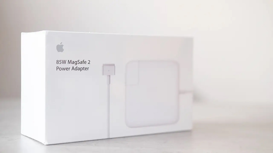 An original authentic MacBook charger is still in its packaging.