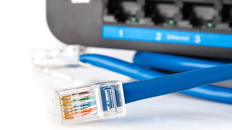An ethernet cable is placed in front of a WiFi router.