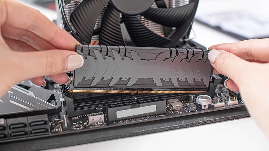 Installing a RAM stick into a computer motherboard's RAM slot.