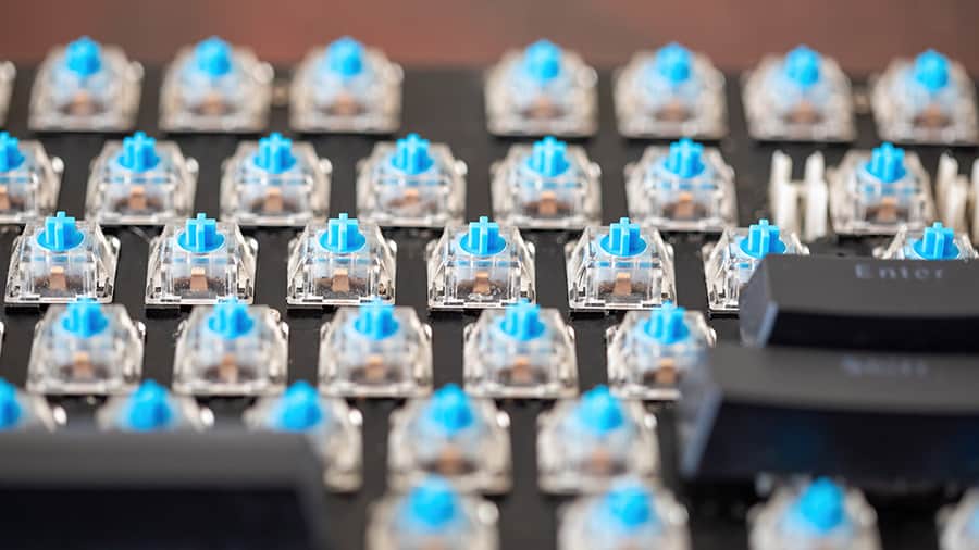 The mechanical switches are exposed after removing the key covers on a mechanical keyboard.