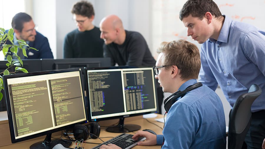 Software developers looking at a computer monitor.