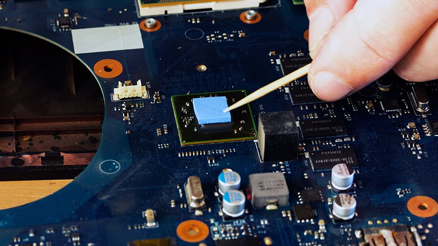 Thermal pad being placed on GPU inside a laptop with one already placed on the CPU.