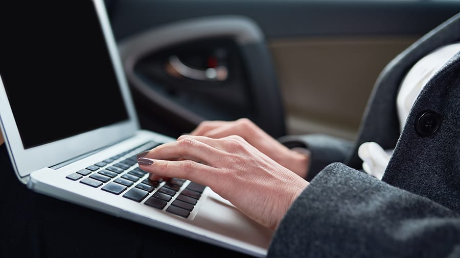 A laptop is being used in a car.