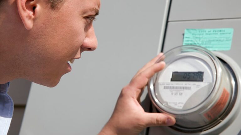 A man is checking the power meter reading.