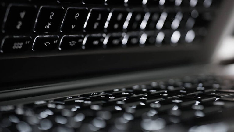 A laptop with white backlit keys on the keyboard.