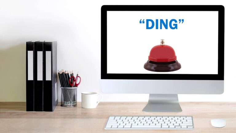 An iMac with a bell on its screen representing a ding sound.