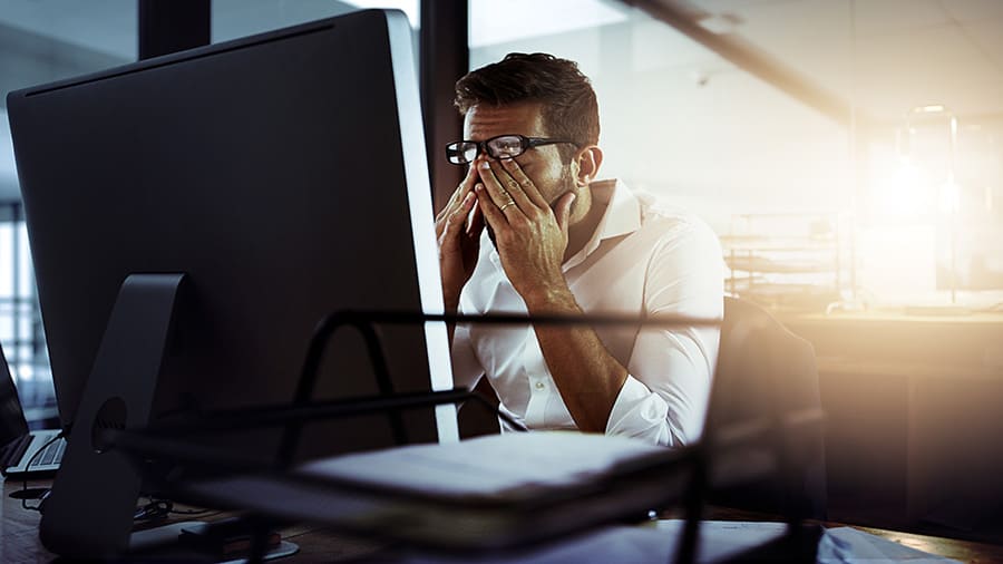 A man is frustrated with a slow computer.